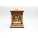 A small walnut cased mantle clock, with an embossed brass dial with Roman numerals, 30cm high, 15.