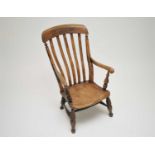 A low Windsor armchair, with elm seat, 98cm high, 46cm wide, 36cm high.