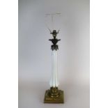 An early 20th century desk lamp, the tapering fluted opaque glass stem below a sconce with cast