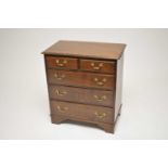 A reproduction oak chest of two short and three long drawers, of diminutive proportions, with