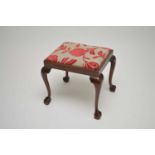 A mahogany stool, the drop-in seat covered in a stylised floral material, above cabriole legs with