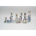 Nine Lladro porcelain figures late 20th century including a boy with a baseball bat, a boy with a