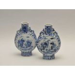 A pair of Chinese blue and white moon flasks, decorated centrally with groups of workers, below