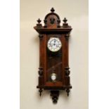 A walnut cased Vienna wall clock with black Roman numerals and a white enamelled dial and 8-day