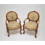 A pair of Victorian upholstered oak elbow chairs, with carved acorn motifs to the backs above