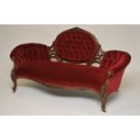A Victorian mahogany framed sofa, the shaped back with scrolling pierced floral mounts, covered in a