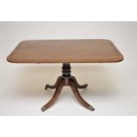 A mahogany breakfast table, with rounded rectangular top, cross-banded in rosewood, over a turned