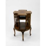 A Victorian oak revolving bookcase, of cruciform shape, with foliate pierced divisions and carved