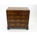 A George III mahogany chest of drawers, the crossbanded top above a brushing slide and two short