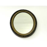 An oval wall mirror with moulded frame and bevelled plate, 64 x 86cm (maximum).