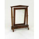 A late Victorian walnut swing toilet mirror, with dentilled pediment, the mirror plate within an