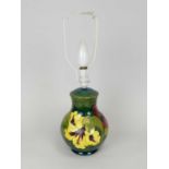 A Moorcroft baluster table lamp 20th century tubelined in the 'Hibiscus' pattern against a dark
