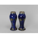 A pair of Royal Doulton vases with silver mounted rims