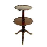A reproduction mahogany two-tier waiter, the scroll edged circular tiers on a tapering column,