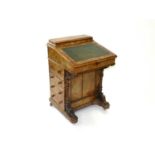 A Victorian figured walnut davenport, the raised top with moulded edge, the writing surface with