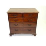 A George III mahogany chest of drawers, the moulded and canted top above two short and three long
