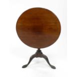 A late Victorian mahogany tilt-top tripod occasional table, the plain circular top on a tapereing