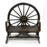 A wagon wheel backed rustic two-seater garden bench, treated with a brown exterior wood stain, 115cm