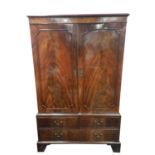 A George III mahogany linen press converted to a wardrobe, with flamed figured, beaded doors and