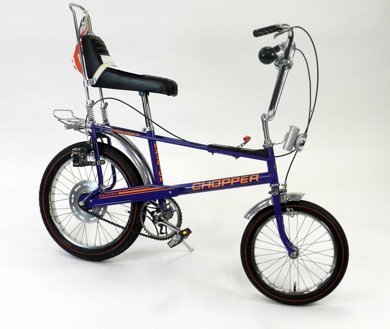 A Raleigh Chopper MkII bicycle, in Ultraviolet livery with orange decals.