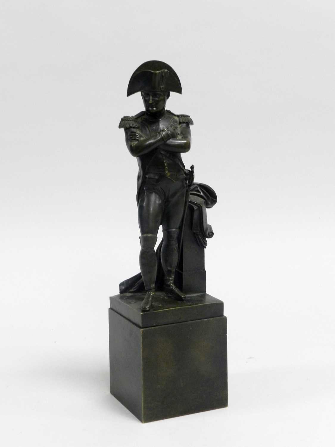 A French bronze figure of Napoleon, modelled standing beside a plinth and set on a pedestal base,