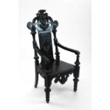 A late 19th century ebonised, Indo-Ceylonese style elbow chair