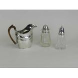 A silver plated jug and two silver mounted glass sugar casters
