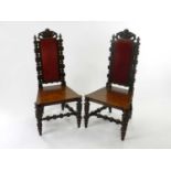 A pair of 19th Century carved oak Flemish style high back side chairs, the upholstered backs with