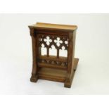 A 20th Century oak gothic carved prayer stool, the sloping top raised on shaped panels with Gothic