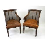 A pair of mahogany bergere type armchairs, with reeded scroll arms and raised on fluted front