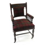 A late Victorian walnut upholstered open armchair, with carved top rail and plaid fabric.