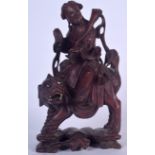 AN EARLY 20TH CENTURY CHINESE CARVED HARDWOOD FIGURE, formed as a female riding a beast upon an outc