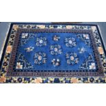 A CHINESE BLUE GROUND PEKING RUG, decorated with panels of foliage. 187 cm x 125 cm.