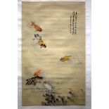 AN EARLY 20TH CENTURY CHINESE PAINTED WATERCOLOUR SILK SCROLL depicting fish swimming amongst reeds.