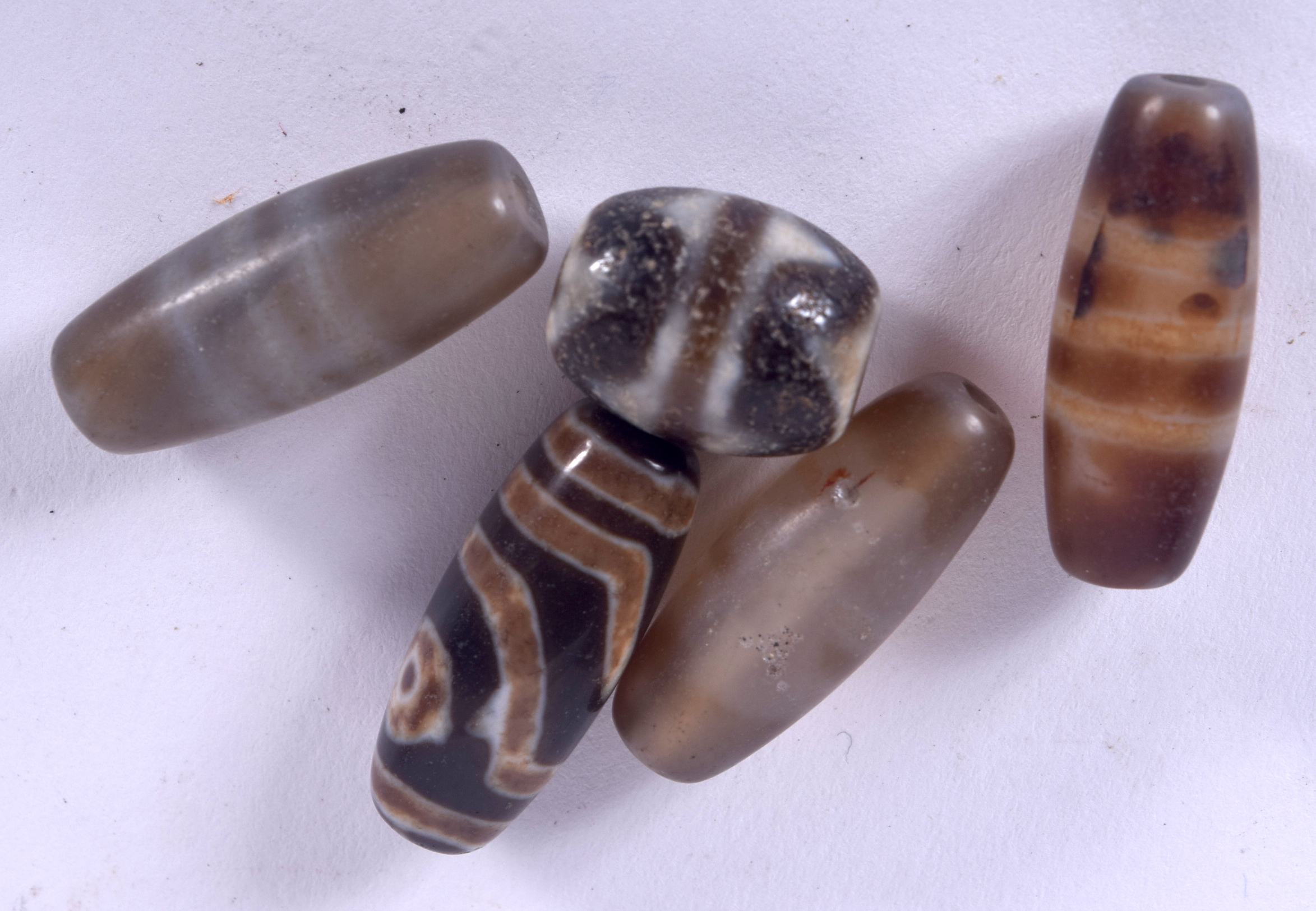 FIVE 20TH CENTURY ZHU BEAD, swirled decoration. Largest 2.25 cm. (5)