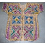 AN ISLAMIC TALISMANIC SHIRT ROBE, decorated with panels of calligraphy. 98 cm x 110 cm.