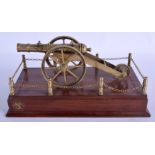 AN EDWARDIAN BRASS SIGNAL TABLE CANNON modelled upon a mahogany base. 30 cm x 14 cm.