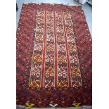 A IKAT TURKMAN RED GROUND RUG, decorated with strips of motifs. 183 cm x 118 cm.