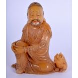 A FINE EARLY 18TH CENTURY CHINESE CARVED SOAPSTONE FIGURE OF LUOHAN Yongzheng, modelled beside a lio