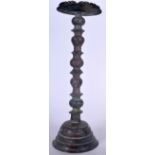 AN ISLAMIC BRONZE OIL LAMP , engraved with symbols and calligraphy. 52 cm high.