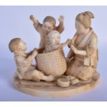 A 19TH CENTURY JAPANESE MEIJI PERIOD CARVED IVORY OKIMONO decorated with a mother and children play