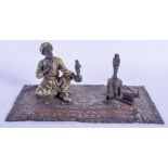 A COLD PAINTED BRONZE FIGURE OF A MALE upon a carpet. 19 cm x 11 cm.