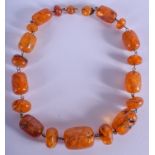 A RARE EARLY 20TH CENTURY CARVED AMBER NECKLACE probably Baltic, carved with flowers. 64 grams. 44