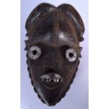 A LIBERIAN WOODEN MANO MASK, set with metal eyes and teeth.