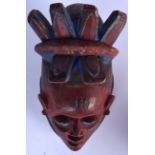 A NIGERIAN YORUBA WOODEN POLYCHROMED GELEDE MASK, carved with feather like headdress. 36 cm x 21 cm