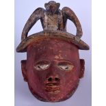 A NIGERIAN YORUBA WOODEN POLYCHROMED GELEDE MASK, carved with a bird finial. 34 cm x 27 cm.