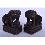 A PAIR OF EARLY 20TH CENTURY CHINESE CARVED SOFTWOOD LIONS Qing, modelled upon rectangular bases. 1