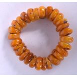 AN AMBER BRACELET, formed with flattened beads. 9 cm wide.