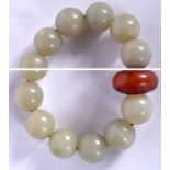 AN EARLY 20TH CENTURY CHINESE JADE SPHERICAL BEAD BRACELET, formed with a flattened amber coloured