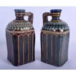 A PAIR OF 19TH CENTURY DOULTON LAMBETH STONEWARE JUGS decorated with motifs. 20.5 cm high.